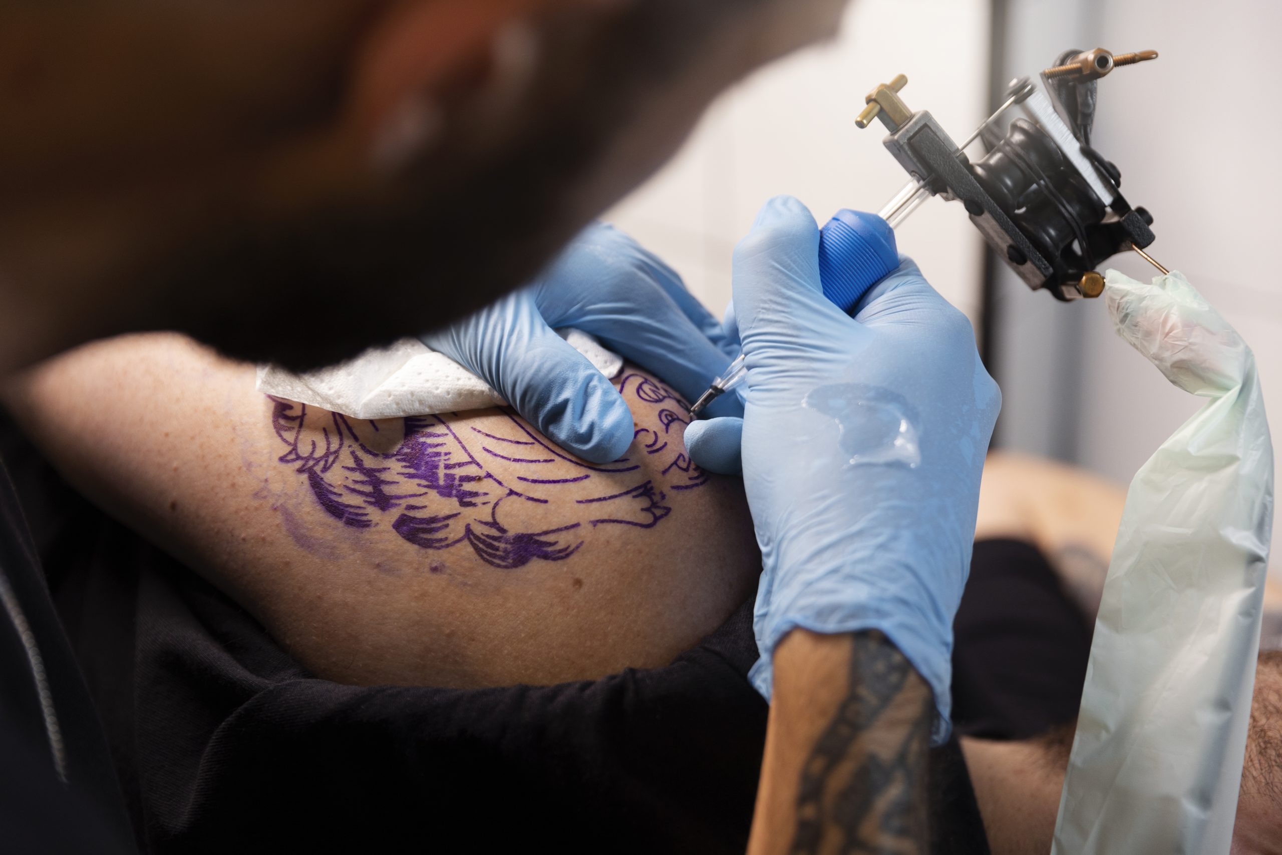 high-angle-talented-tattoo-artist-doing-his-job