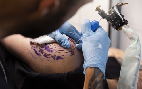 high-angle-talented-tattoo-artist-doing-his-job